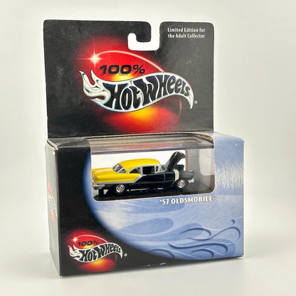A Hot Wheels '57 Oldsmobile diecast car in its original packaging, featuring a yellow and black car with the hood open.