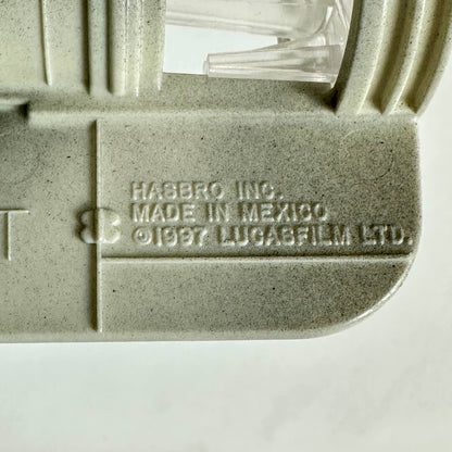 Close-up of a light gray plastic part with embossed text reading 'HASBRO INC. MADE IN MEXICO © 1987 LUCASFILM LTD.
