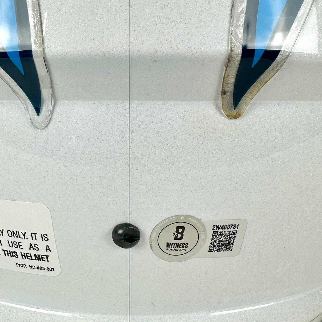 Close-up of a helmet with a Beckett brand label and QR code on a white background