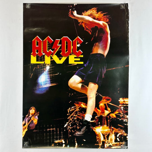Poster of AC/DC with a person on stage and band members in the background.