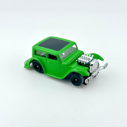 Green toy car with black roof against a white background