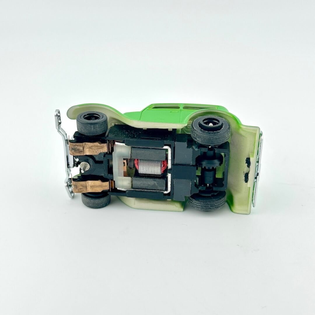 Close-up of a mechanical device with green and black components on a white background