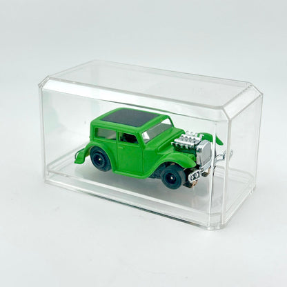 Green model car in a clear display case on a white background