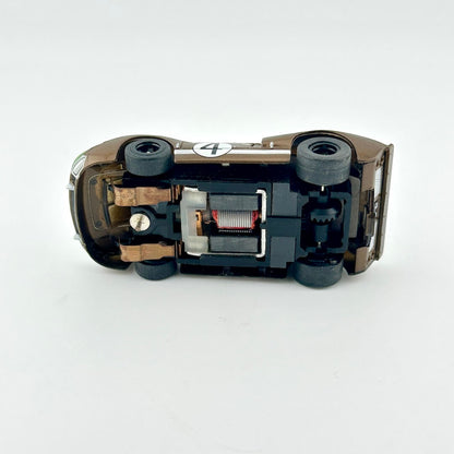 Close-up of a underside of slot car with visible components on a white background