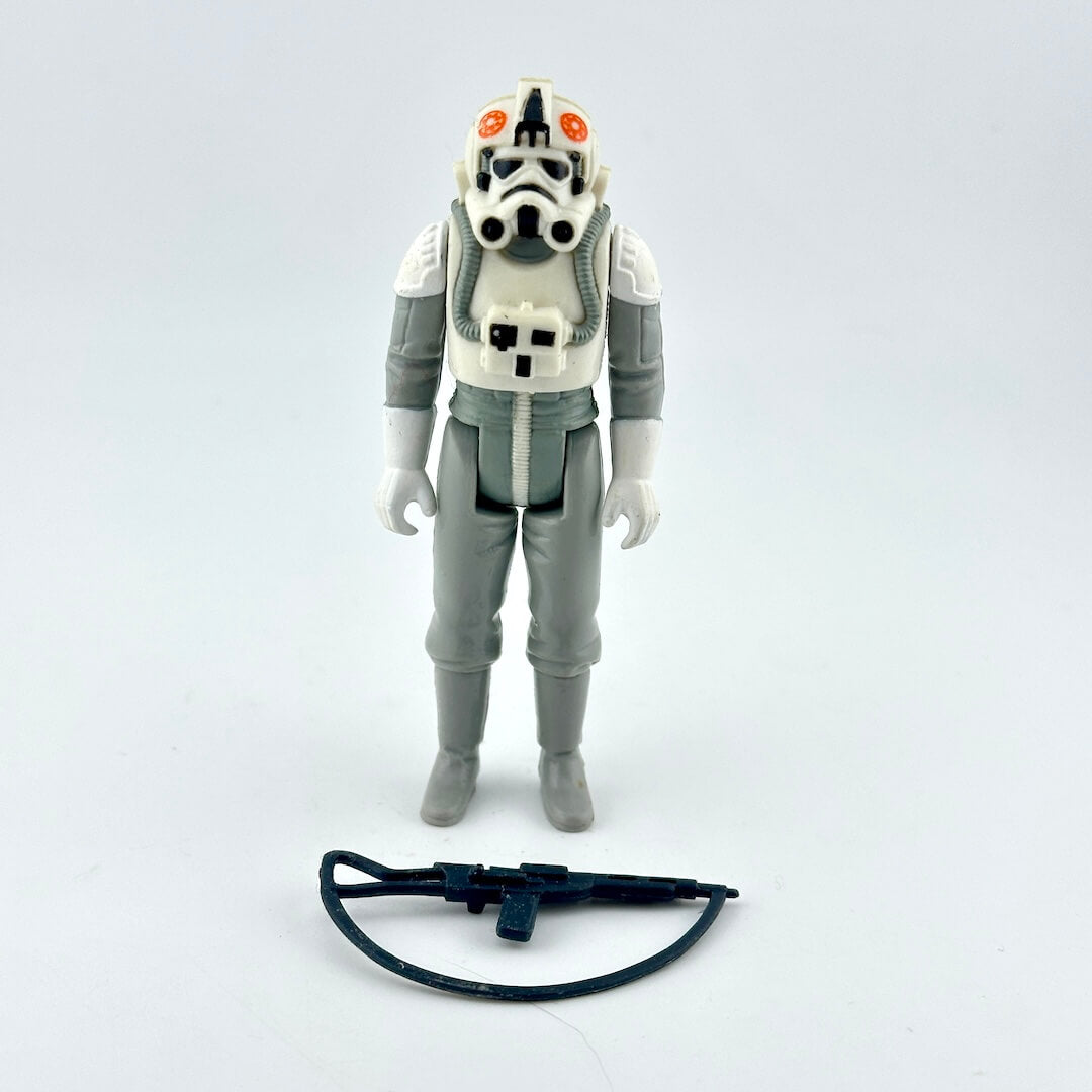 A vintage Star Wars plastic action figure of an AT-AT Driver in white and gray uniform with black accessory. 