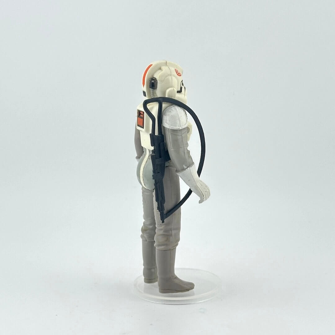 Toy figure of a character in a gray and white suit with helmet on a white background