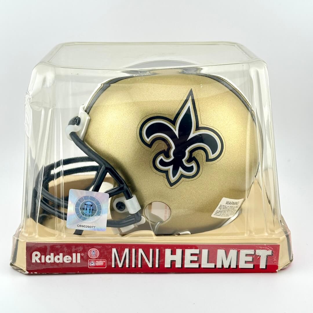 Riddell mini football helmet with New Orleans Saints logo in clear packaging on a white background