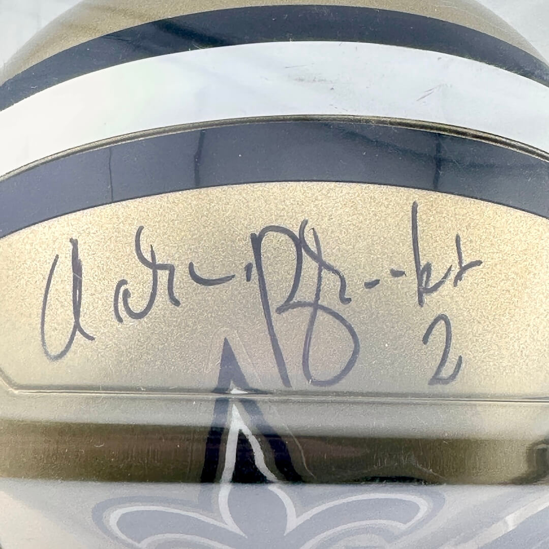 Close-up of a helmet with a signature and number on a reflective surface
