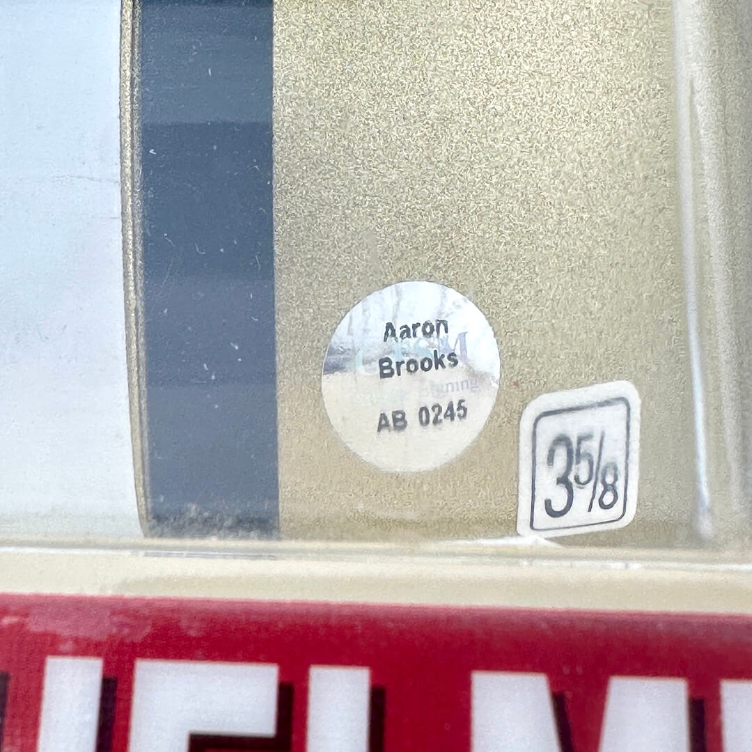 Close-up of a label with 'Aaron Brooks' and 'AB 0245' on a reflective surface.
