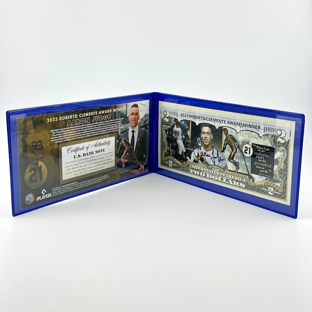 Collectible $2 bill with images of baseball players superimposed on currency next to certificate of authenticity. 