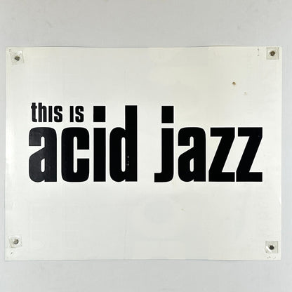 White sign with black text 'this is acid jazz' on a white background