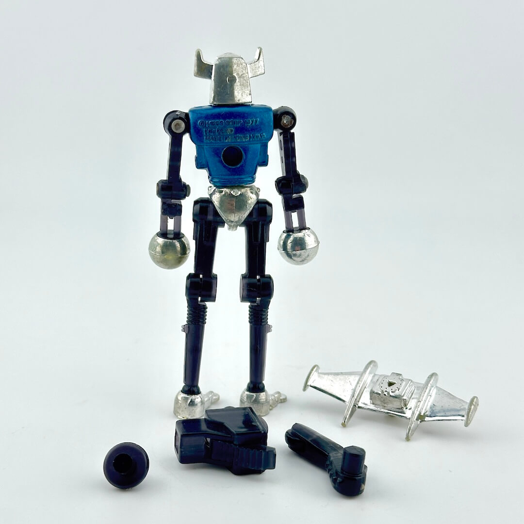 A blue and silver toy robot action figure with several loose accessories arranged in front of it.