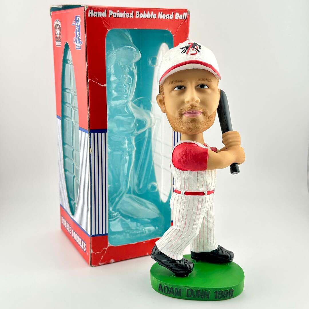 Bobblehead figure of a baseball player holding a bat in front of its packaging