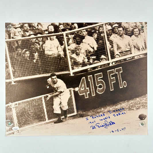 Vintage black and white photo of a baseball player near a field wall. 