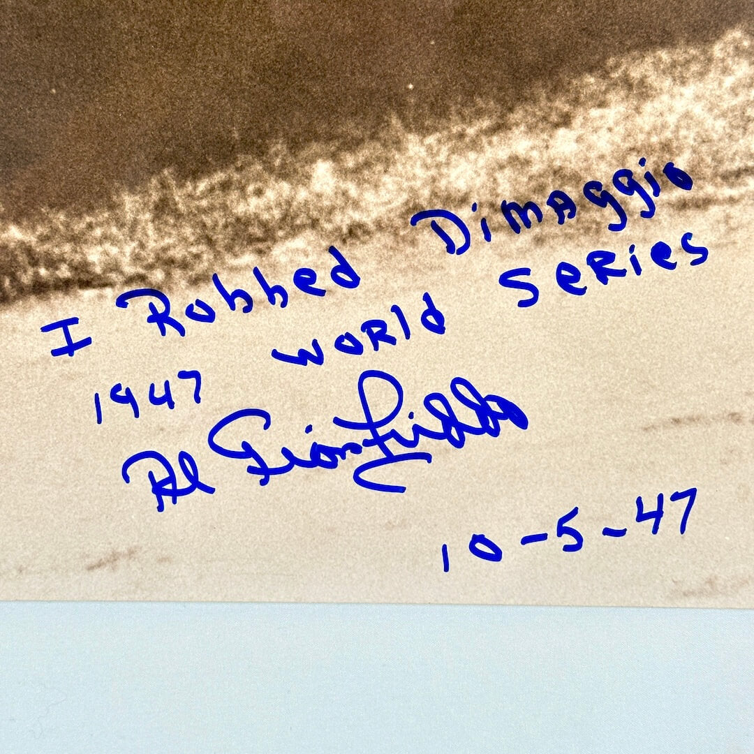 Text in blue ink on a textured background, a signature and inscription.