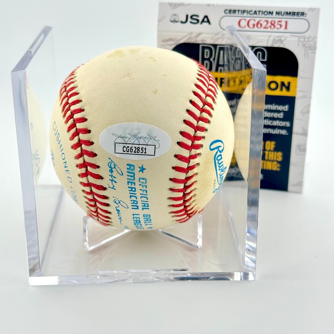 Signed baseball in clear display against white background. With certificate of authenticity. 