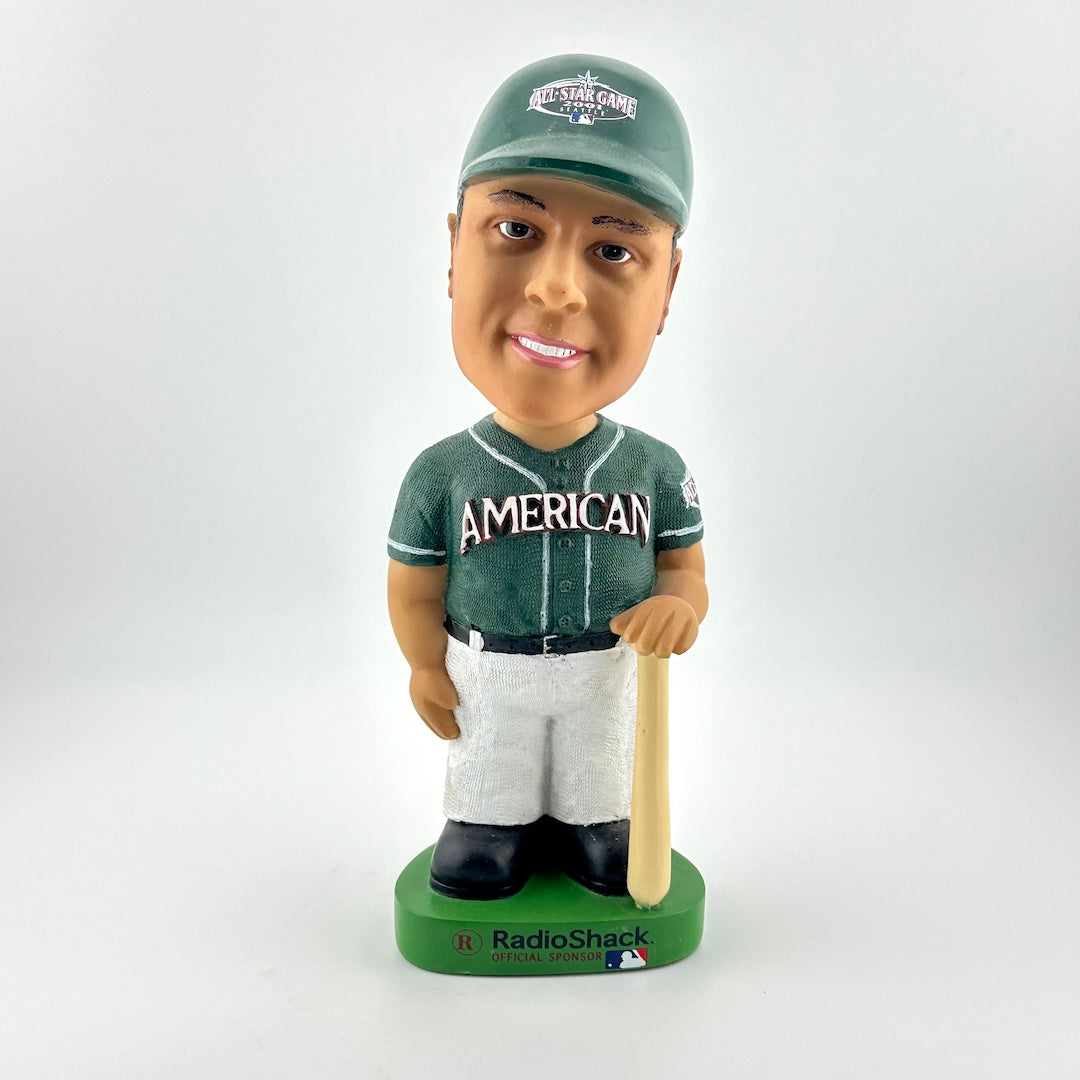Bobblehead figure of a baseball player in a green uniform with 'American' on the jersey, holding a bat, on a white background.