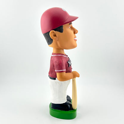 Bobblehead figure of a baseball player in a red uniform with a bat on a white background