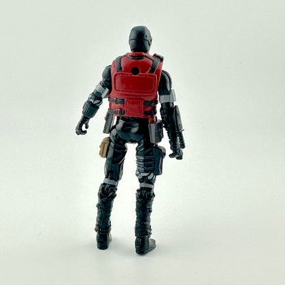 A back view of a black and red action figure with tactical gear, standing against a plain light gray background.