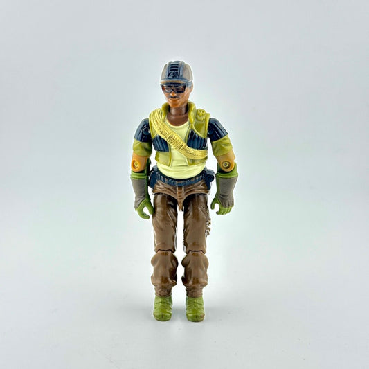 A vintage action figure of a soldier wearing a brown hat, black and green tactical vest, brown pants, and green boots.
