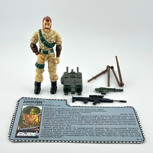 GI Joe action figure with accessories and character card against white background. 