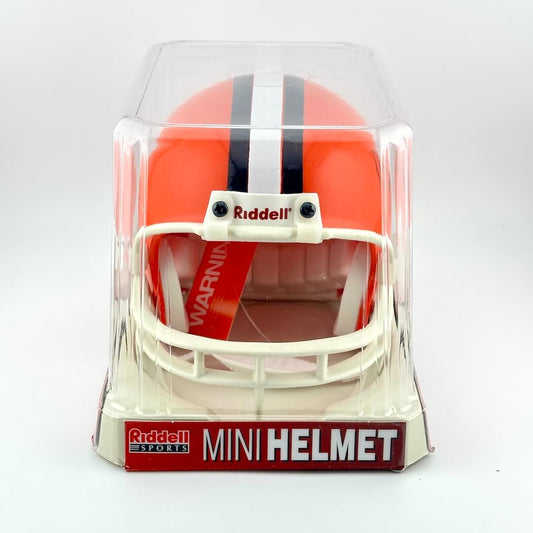 Orange mini football helmet with black and white stripes in clear packaging, featuring Riddell branding.