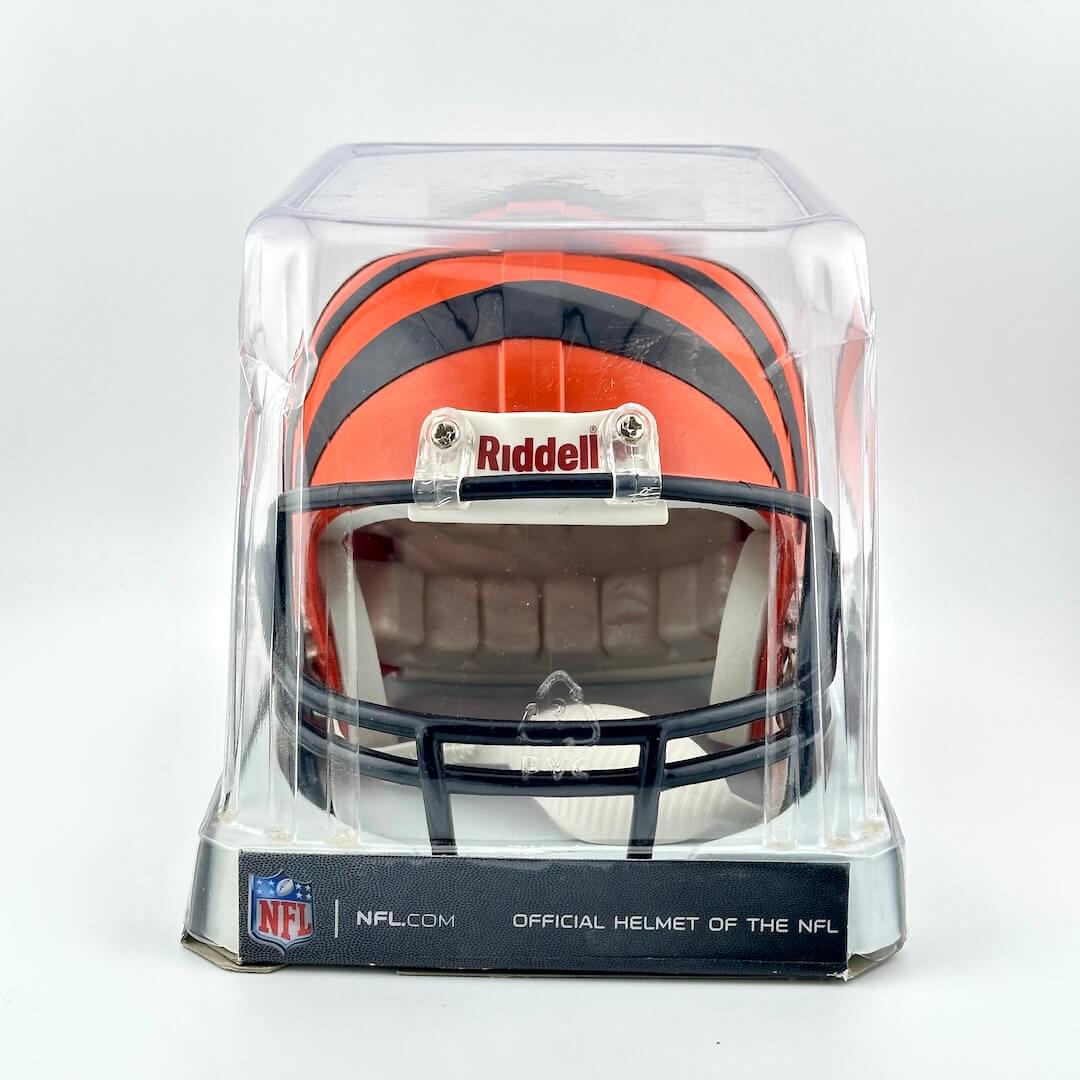 Miniature football helmet in a clear display case with Riddell and NFL branding on a white background