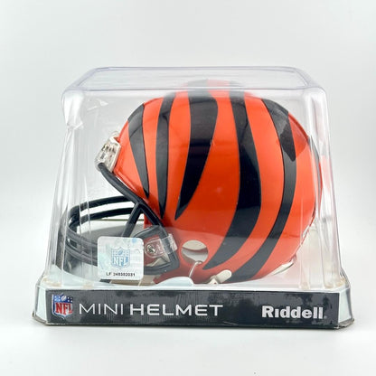 Riddell mini football helmet with orange and black stripes in clear packaging on a white background