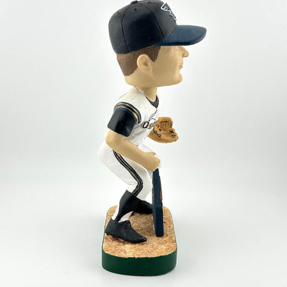 Bobblehead of a baseball player in a uniform with a cap and glove on a white background