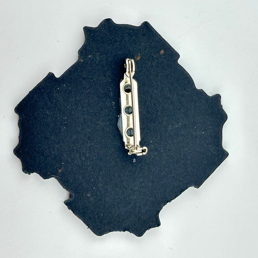 Backside of pin against white background. 