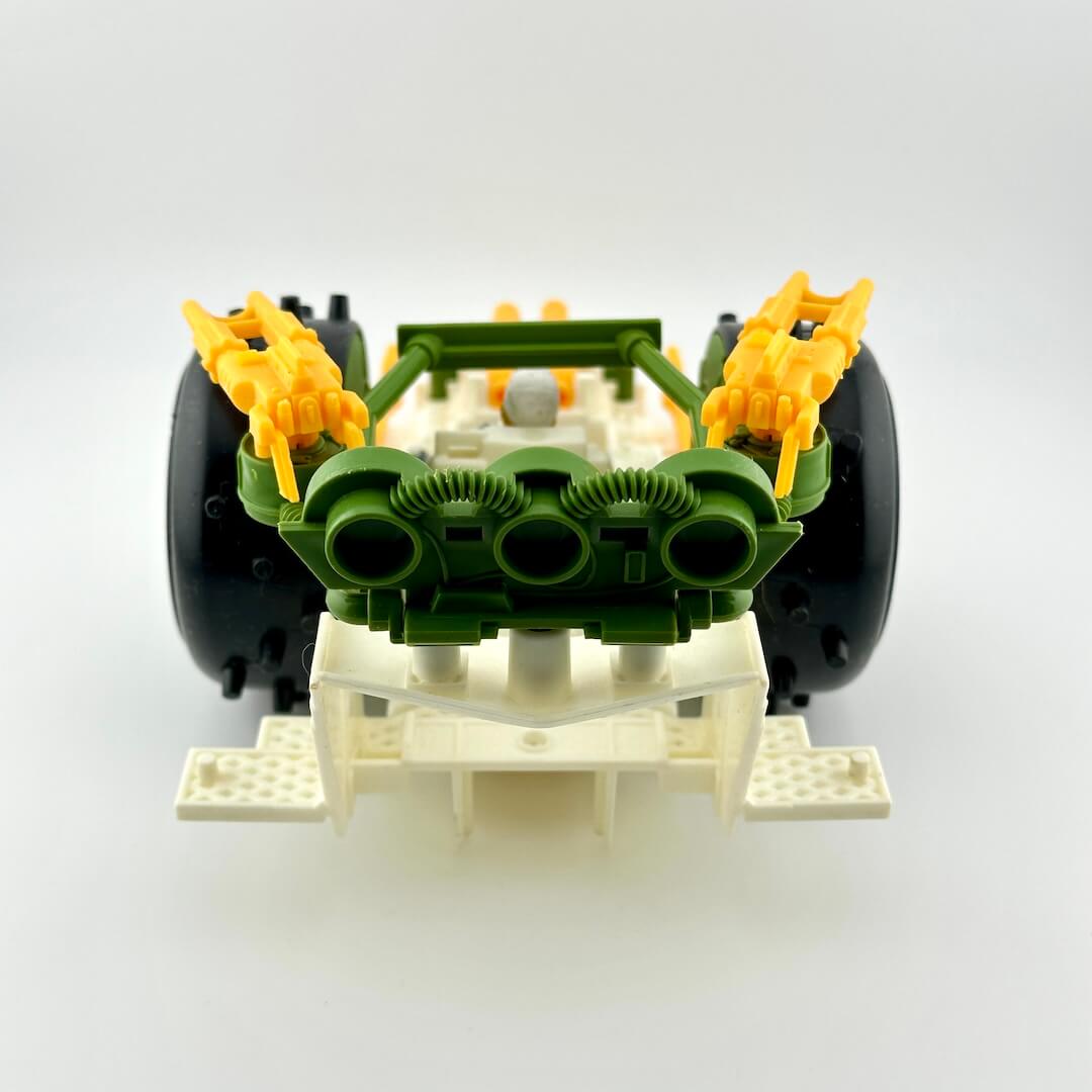 Toy car engine model with green pistons and yellow accents on a white background