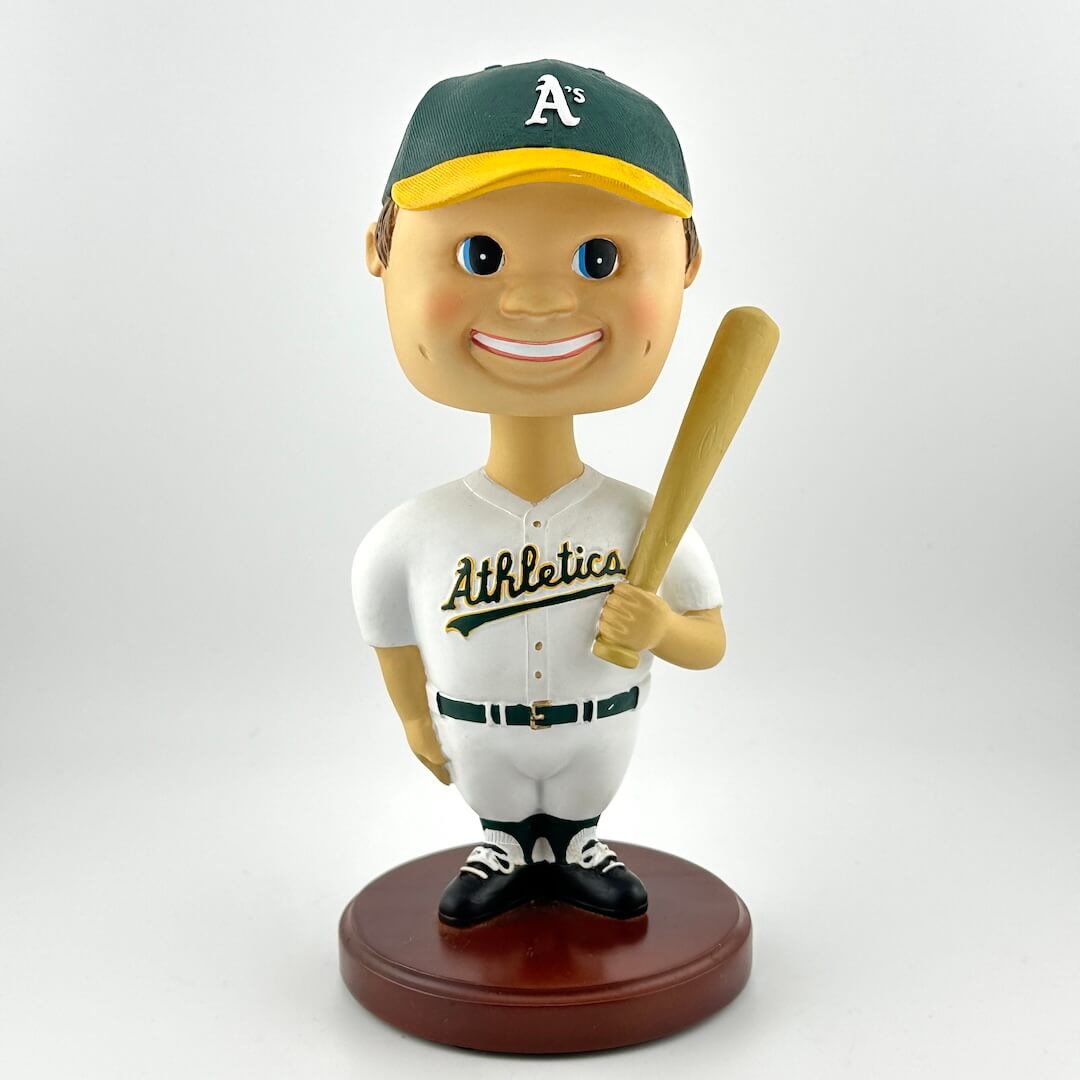 Bobblehead figure of a baseball player in an Athletics uniform with a bat on a white background