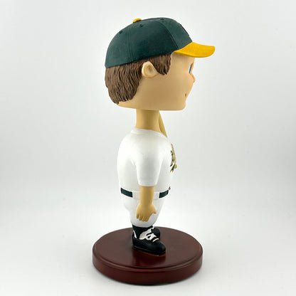 Bobblehead figure of a baseball player in a green and yellow uniform on a white background