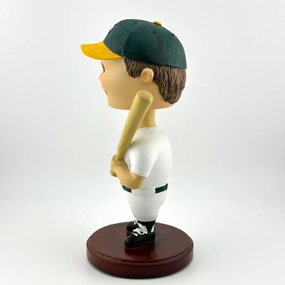 Bobblehead of a baseball player in a green and yellow uniform with a bat on a white background