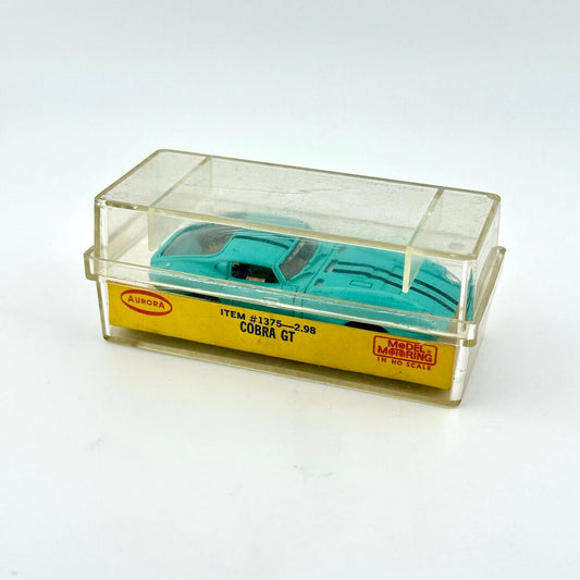 Model car in a transparent display case with a label on a white background