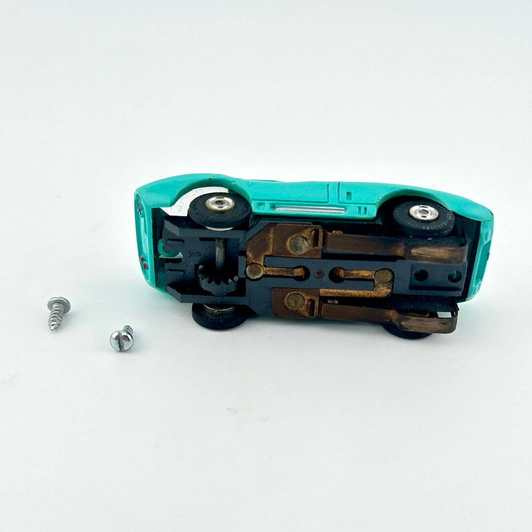 underside of slot car with two screws on a white background