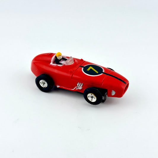Red slot car with driver against white background.