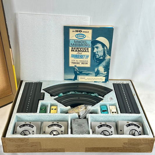 Slot car set with track layout and accessories in a box, featuring original instructions book.