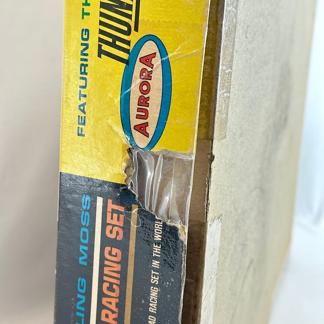 Close-up of a vintage Aurora model racing set packaging with visible wear.