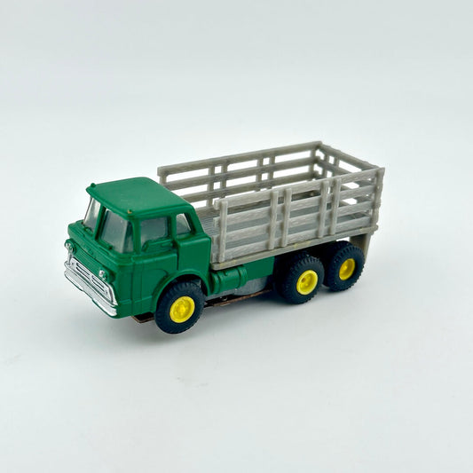 Model truck with green cab and gray trailer on a white background