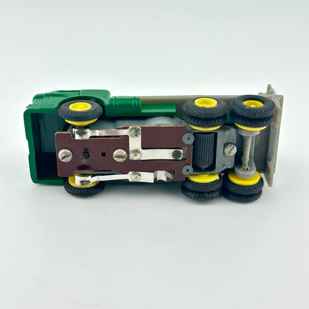 Toy truck model with green body, yellow wheels, and metallic parts on a white background