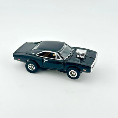 Black toy car with silver accents against white background. 