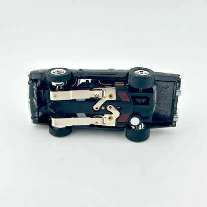 Underside of slot car to show components on white background.