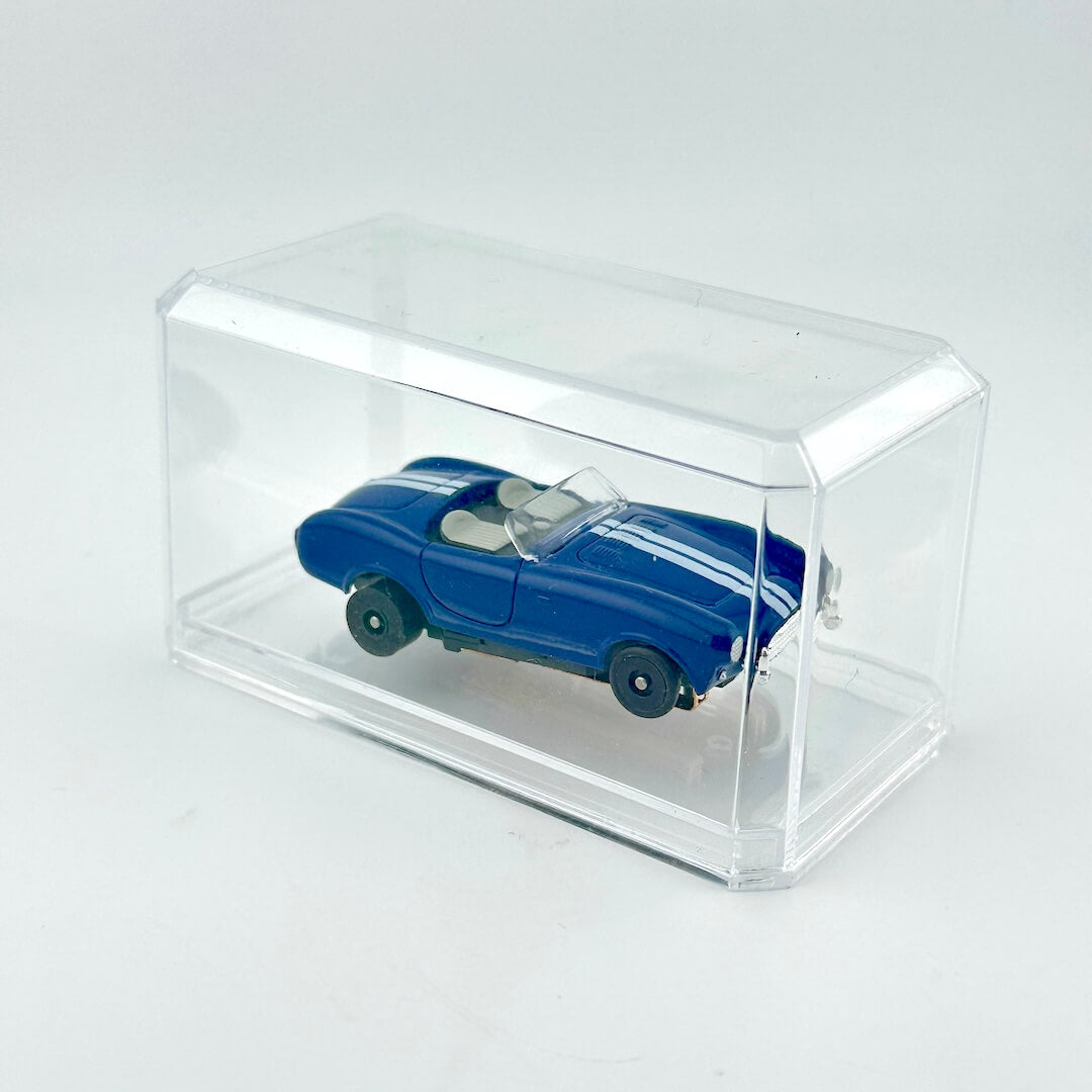 Blue model car in a clear display case on a white background
