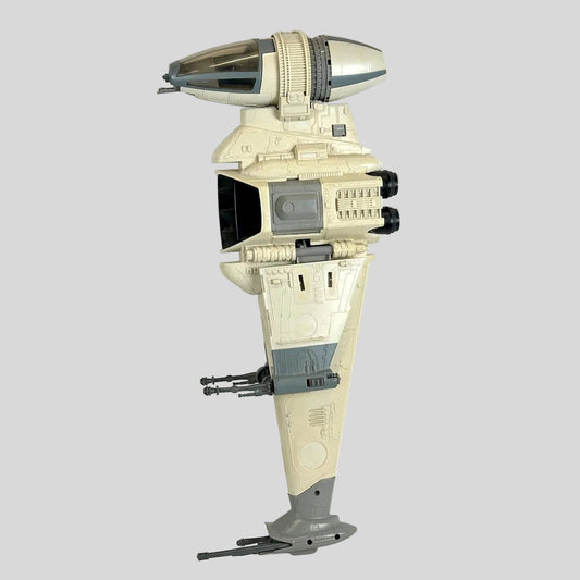 A vintage Star Wars toy B-wing Starfighter model, shown in a side profile view against a plain white background.