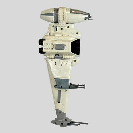 A Star Wars toy model spaceship, featuring a cream-colored hull with gray and black accents.