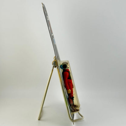 Small figurine inside a transparent box with a stand on a white background