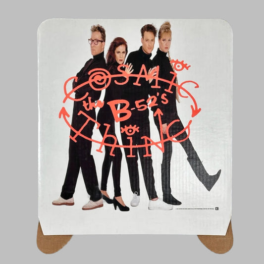 White cardboard square with image of band dressed in black with band & album name written in red/orange across middle.