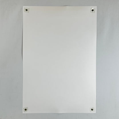 Backside of poster with magnets in corners on light gray background. 