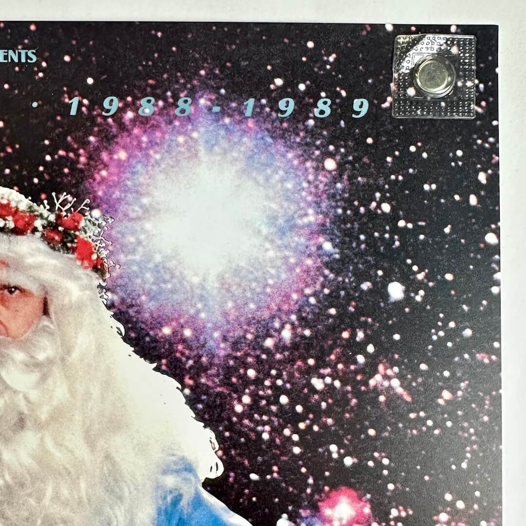 Top right corner of poster with no visible wear or damage held by magnet onto light surface. 